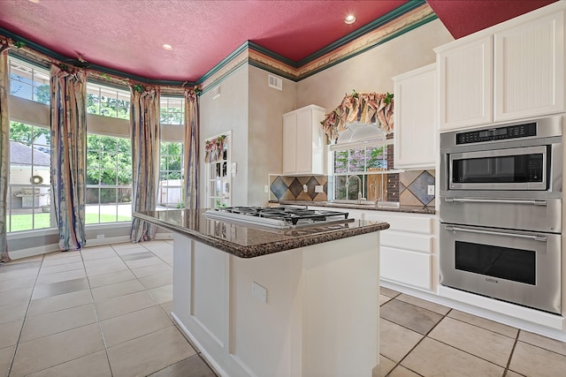 6102 Walkers Park Dr, Sugar Land, TX 77479 - kitchen featuring stainless steel appliances, a textured ceiling, light tile patterned floors, a warming drawer, and white cabinetry