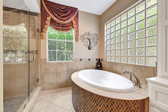 6102 Walkers Park Dr, Sugar Land, TX 77479 - bathroom with healthy amount of natural light, a garden tub, a stall shower, tile patterned floors, and tile walls