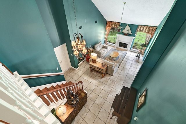 6102 Walkers Park Dr, Sugar Land, TX 77479 - living area featuring light tile patterned floors, vaulted ceiling, a fireplace, and a chandelier