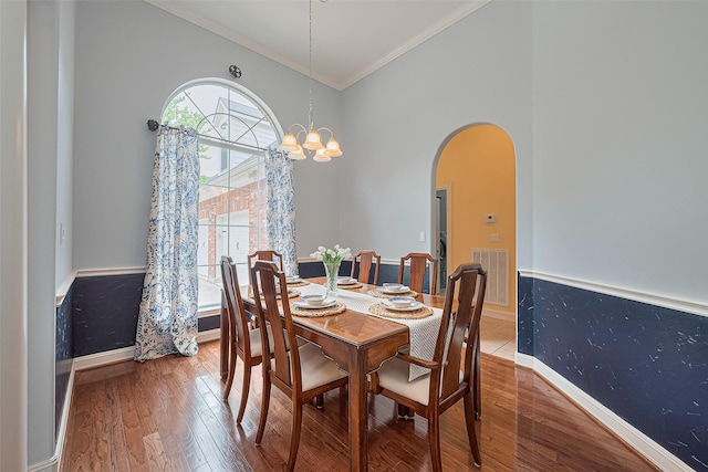 13820 Midway Dr, Willis, TX 77318 - dining area featuring wood finished floors, arched walkways, crown molding, and a chandelier