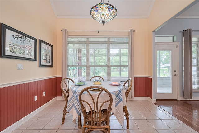 13820 Midway Dr, Willis, TX 77318 - dining area featuring a wainscoted wall, crown molding, light tile patterned flooring, and wood walls