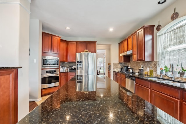 3318 Legends Mist Dr, Spring, TX 77386 - kitchen featuring appliances with stainless steel finishes, decorative backsplash, under cabinet range hood, dark stone countertops, and recessed lighting