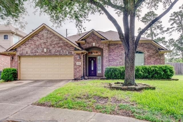 10406 Friars Hill Ln, Houston, TX 77070 - view of front of home with a garage, brick siding, and concrete driveway