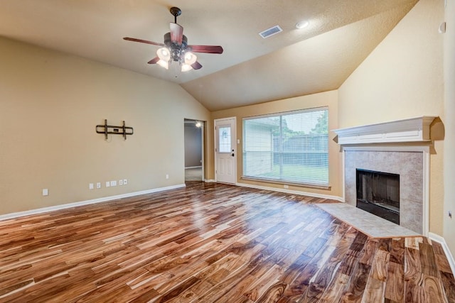 10406 Friars Hill Ln, Houston, TX 77070 - unfurnished living room featuring ceiling fan, wood finished floors, lofted ceiling, and a tile fireplace