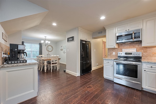 152 Snug Harbor Dr, Conroe, TX 77356 - kitchen featuring appliances with stainless steel finishes, a chandelier, white cabinets, dark wood-style flooring, and recessed lighting