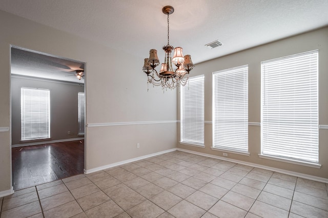 16311 Sylvan Dale Dr, Humble, TX 77346 - empty room featuring light tile patterned floors, a chandelier, a textured ceiling, and a ceiling fan