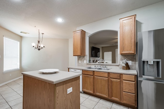 16311 Sylvan Dale Dr, Humble, TX 77346 - kitchen featuring stainless steel fridge, tasteful backsplash, light tile patterned floors, a kitchen island, and light countertops