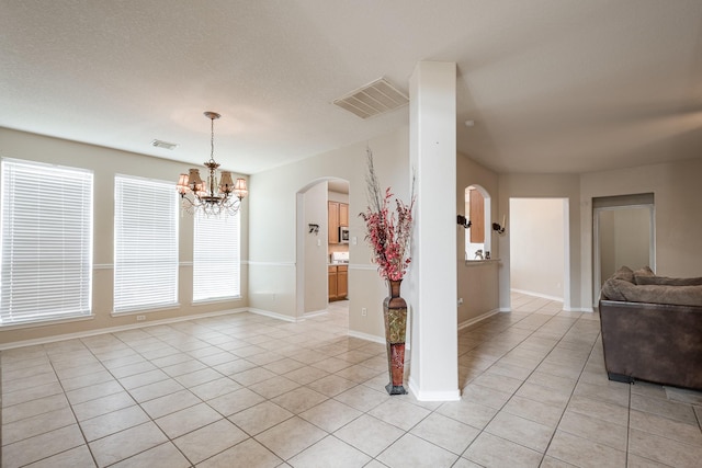 16311 Sylvan Dale Dr, Humble, TX 77346 - unfurnished room with light tile patterned flooring, arched walkways, and a chandelier