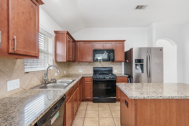20930 Morgan Knoll Ln, Katy, TX 77449 - kitchen with black appliances, vaulted ceiling, backsplash, arched walkways, and light tile patterned floors