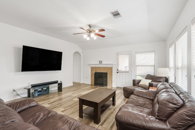20930 Morgan Knoll Ln, Katy, TX 77449 - living room with light wood finished floors, vaulted ceiling, arched walkways, ceiling fan, and a tile fireplace
