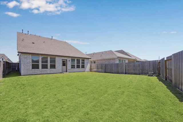 7227 Songlark Landing Ct, Katy, TX 77493 - back of property with a fenced backyard, brick siding, and roof with shingles