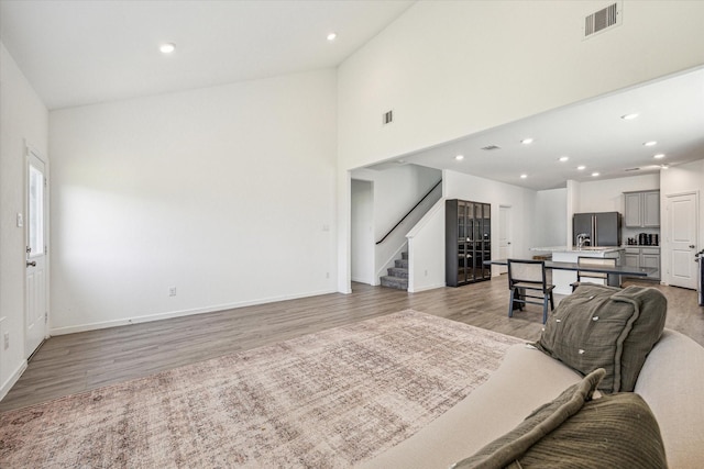 7227 Songlark Landing Ct, Katy, TX 77493 - living area with stairway, light wood-type flooring, recessed lighting, and high vaulted ceiling