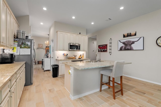 9171 White Tail Dr, Conroe, TX 77303 - kitchen with stainless steel appliances, tasteful backsplash, light wood-style floors, light stone countertops, and recessed lighting