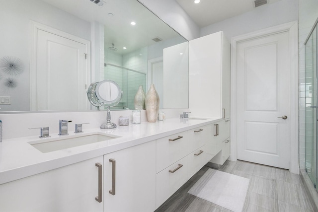1211 Caroline St Unit 1504, Houston, TX 77002 - bathroom featuring a stall shower, double vanity, and recessed lighting