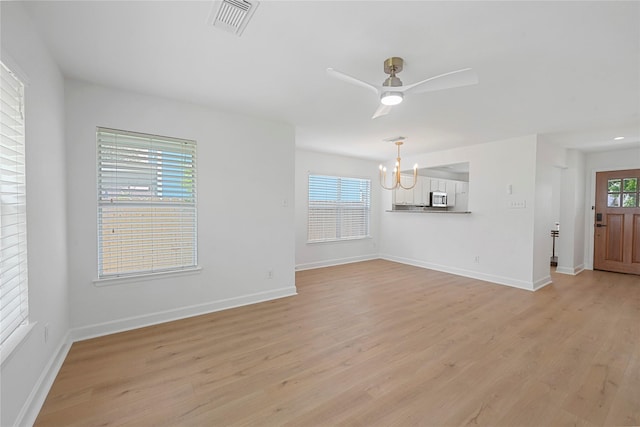 206 Delaney St, Houston, TX 77009 - unfurnished living room featuring a chandelier, light wood-style floors, and a ceiling fan