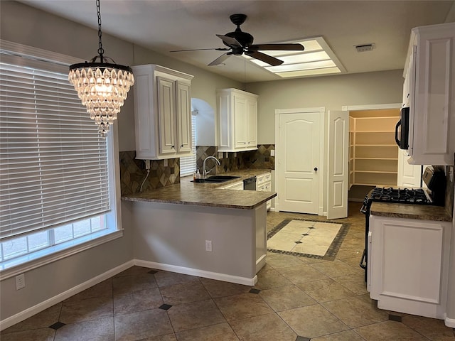 6507 Stone Briar Dr, Pasadena, TX 77505 - kitchen with black microwave, ceiling fan, backsplash, a chandelier, and white cabinetry