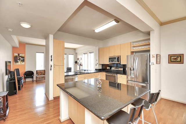 3505 Sage Rd Unit 2910, Houston, TX 77056 - kitchen with stainless steel appliances, light brown cabinets, light wood-type flooring, and a kitchen bar