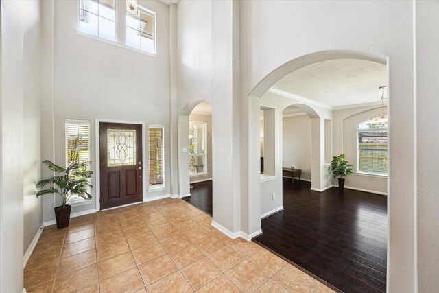 2332 Shadow Falls Ln, Pearland, TX 77584 - tiled foyer with a chandelier, arched walkways, a high ceiling, and crown molding