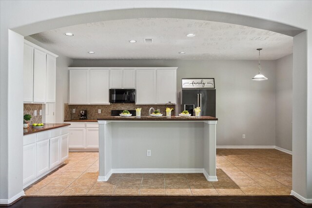 2332 Shadow Falls Ln, Pearland, TX 77584 - kitchen featuring black microwave, stainless steel refrigerator with ice dispenser, dark countertops, decorative backsplash, and recessed lighting