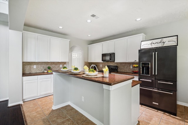 2332 Shadow Falls Ln, Pearland, TX 77584 - kitchen with high end refrigerator, black microwave, white cabinetry, arched walkways, and recessed lighting