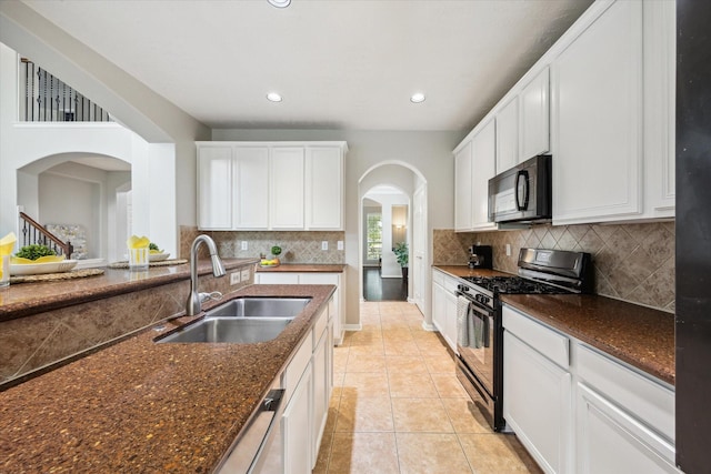 2332 Shadow Falls Ln, Pearland, TX 77584 - kitchen featuring black appliances, arched walkways, white cabinets, recessed lighting, and backsplash