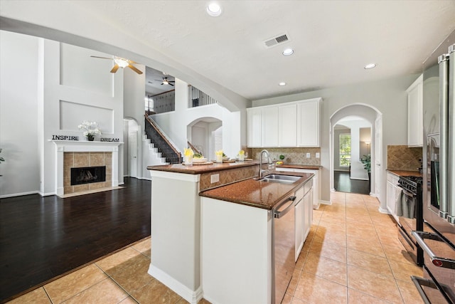 2332 Shadow Falls Ln, Pearland, TX 77584 - kitchen featuring ceiling fan, stainless steel appliances, arched walkways, backsplash, and light tile patterned floors