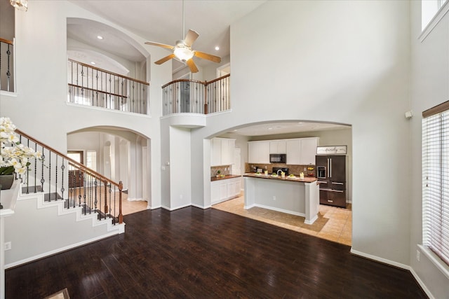 2332 Shadow Falls Ln, Pearland, TX 77584 - unfurnished living room featuring a towering ceiling, ceiling fan, light wood-style flooring, stairway, and recessed lighting
