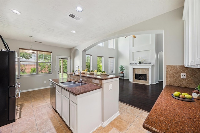 2332 Shadow Falls Ln, Pearland, TX 77584 - kitchen featuring freestanding refrigerator, light tile patterned floors, white cabinets, dishwasher, and an island with sink