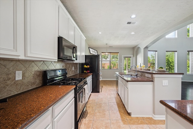2332 Shadow Falls Ln, Pearland, TX 77584 - kitchen with black appliances, tasteful backsplash, white cabinetry, light tile patterned floors, and dark stone counters