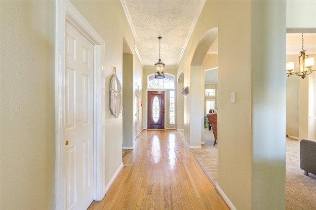 23742 Indian Hills Way, Katy, TX 77494 - foyer entrance featuring crown molding, a chandelier, arched walkways, and light wood-style floors