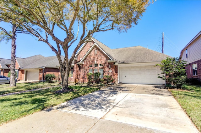 23742 Indian Hills Way, Katy, TX 77494 - view of front of home with brick siding, driveway, a garage, and a front lawn