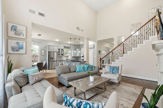 9523 Sapphire Hill Ln, Katy, TX 77494 - living area with a high ceiling, stairs, wood finished floors, and ornate columns