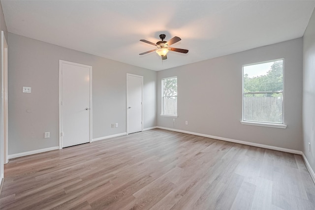 1811 Elm Shadow Dr, Missouri City, TX 77489 - unfurnished bedroom with light wood-style flooring, two closets, and a ceiling fan