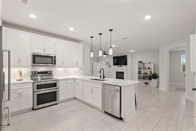 6804 Westview Dr Unit 1307, Houston, TX 77055 - kitchen featuring stainless steel appliances, open floor plan, a peninsula, backsplash, and white cabinetry