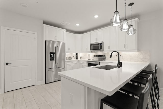 6804 Westview Dr Unit 1307, Houston, TX 77055 - kitchen with stainless steel appliances, a peninsula, a kitchen bar, light countertops, and recessed lighting