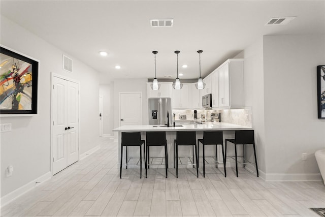 6804 Westview Dr Unit 1307, Houston, TX 77055 - kitchen featuring stainless steel appliances, a peninsula, light countertops, a kitchen breakfast bar, and white cabinets