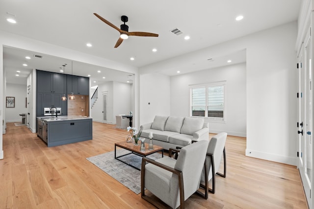 1313 Waverly St, Houston, TX 77008 - living room featuring a ceiling fan, stairway, light wood-style floors, and recessed lighting