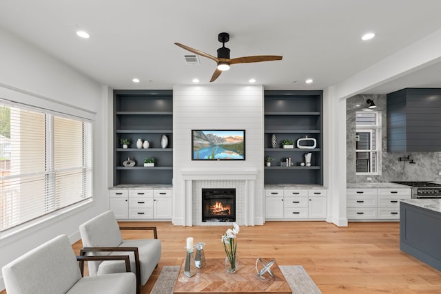 1313 Waverly St, Houston, TX 77008 - living area featuring a ceiling fan, a large fireplace, light wood-type flooring, recessed lighting, and built in shelves