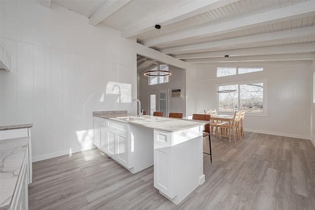492 Trinity Rd, Dayton, TX 77535 - kitchen with light wood-style flooring, light stone countertops, a peninsula, white cabinetry, and pendant lighting
