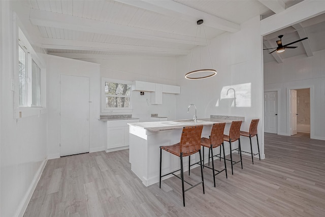492 Trinity Rd, Dayton, TX 77535 - kitchen with light wood finished floors, white cabinets, a breakfast bar area, decorative light fixtures, and a ceiling fan