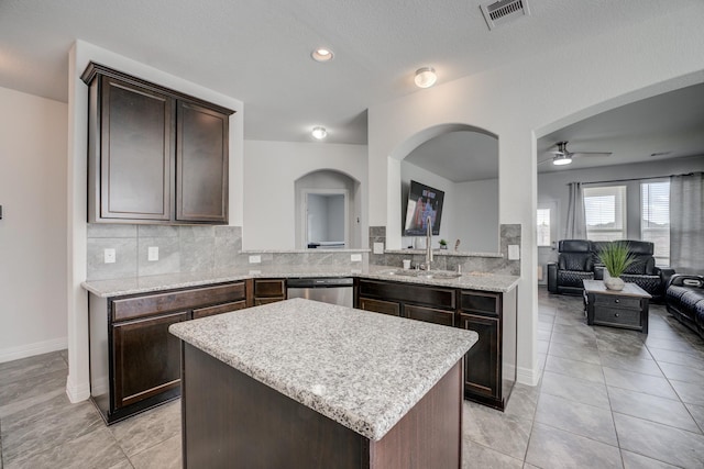 3502 Singing Flower Ln, Richmond, TX 77406 - kitchen featuring stainless steel dishwasher, dark brown cabinetry, a ceiling fan, open floor plan, and tasteful backsplash