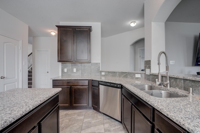 3502 Singing Flower Ln, Richmond, TX 77406 - kitchen featuring dishwasher, arched walkways, dark brown cabinets, and light stone counters