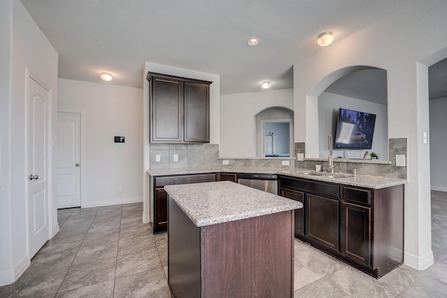 3502 Singing Flower Ln, Richmond, TX 77406 - kitchen featuring stainless steel dishwasher, decorative backsplash, a center island, dark brown cabinetry, and light stone counters