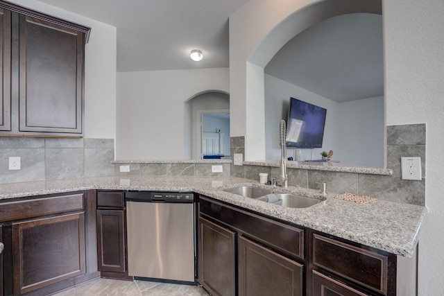 3502 Singing Flower Ln, Richmond, TX 77406 - kitchen with dishwasher, arched walkways, dark brown cabinetry, and light stone countertops