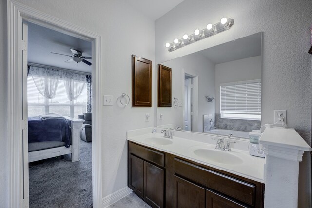 3502 Singing Flower Ln, Richmond, TX 77406 - bathroom featuring double vanity, connected bathroom, a garden tub, a ceiling fan, and a textured wall