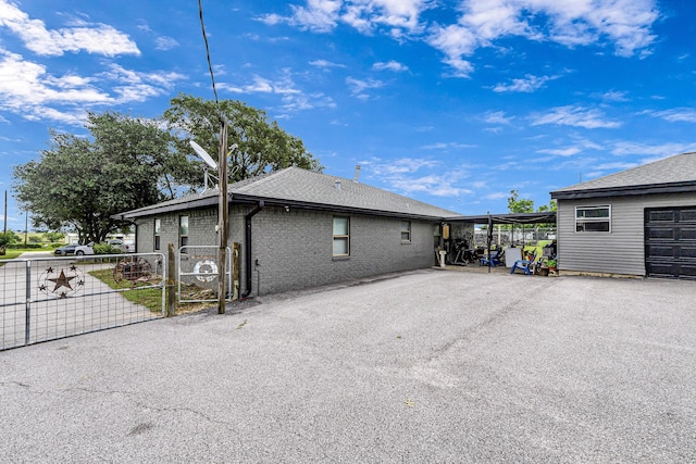 5673 Fm 1094th Rd, Sealy, TX 77474 - view of property exterior with a gate, brick siding, and a shingled roof