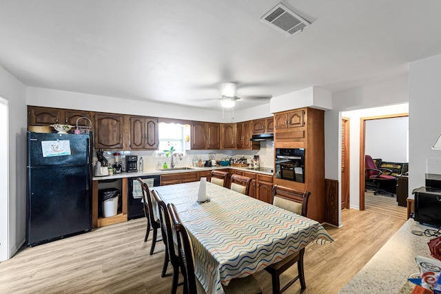 5673 Fm 1094th Rd, Sealy, TX 77474 - kitchen with black appliances, ventilation hood, light countertops, light wood-style flooring, and a ceiling fan