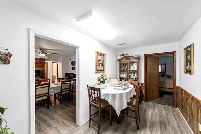 5673 Fm 1094th Rd, Sealy, TX 77474 - dining space with wood finished floors, a wainscoted wall, and a ceiling fan