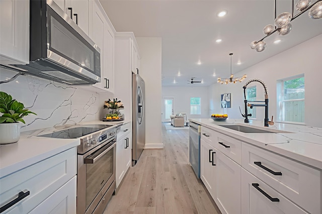 6749 Liverpool St, Houston, TX 77021 - kitchen with stainless steel appliances, recessed lighting, plenty of natural light, white cabinetry, and light wood finished floors
