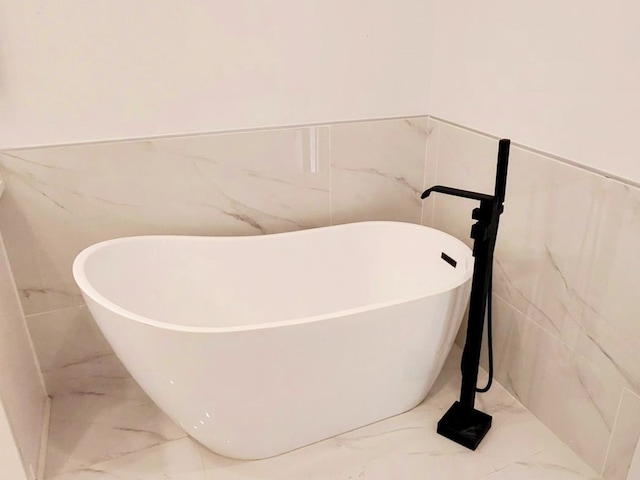 6749 Liverpool St, Houston, TX 77021 - bathroom featuring marble finish floors, a freestanding bath, and tile walls